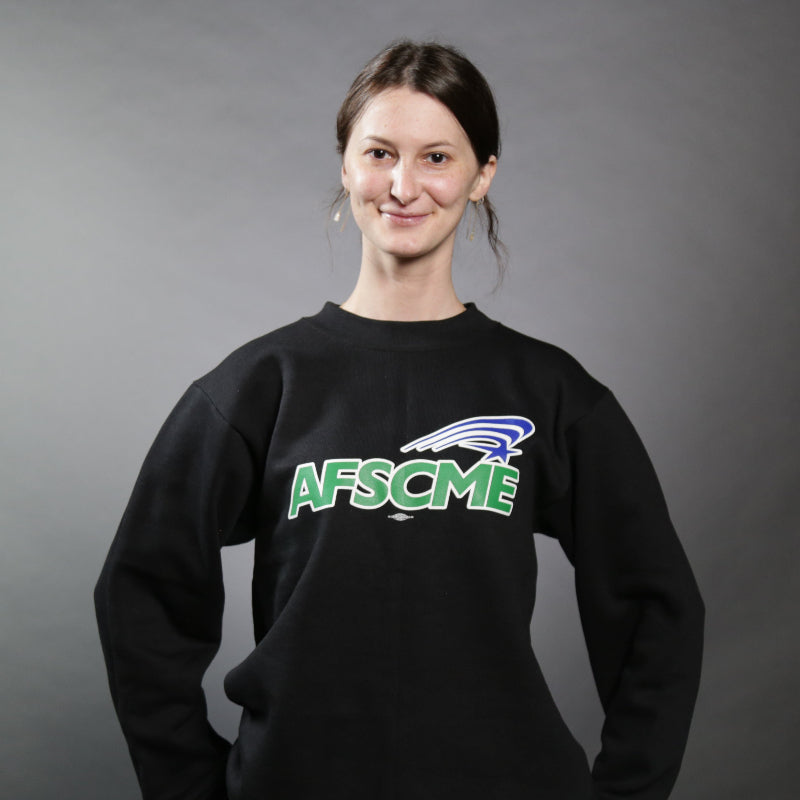 Person wearing a black AFSCME sweatshirt against a gray background
